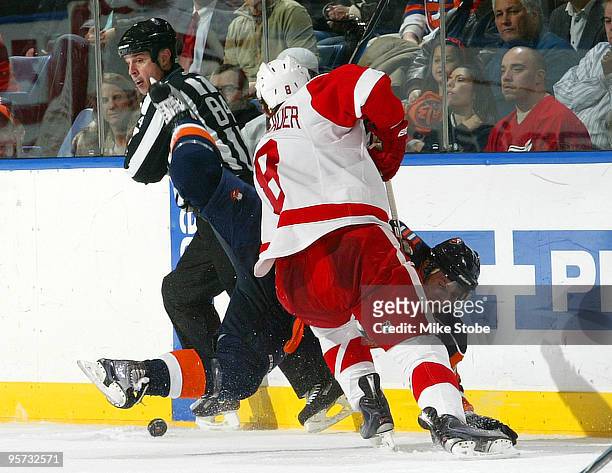 Justin Abdelkader of the Detroit Red Wings checks Sean Bergenheim of the New York Islanders hard to the ice on January 12, 2010 at Nassau Coliseum in...