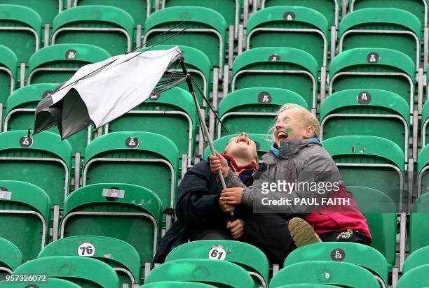 Twelve year old Aran Cavanagh and his sister, eleven year old Joise battle with their umbrella as wind and rain sweeps across Malahide cricket club,...