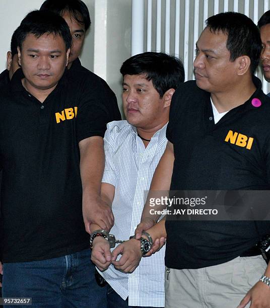 Philippine Muslim politician Andal Ampatuan Jnr is hauled to a Manila court in handcuffs by two National Bureau of Investigation agents in Manila on...