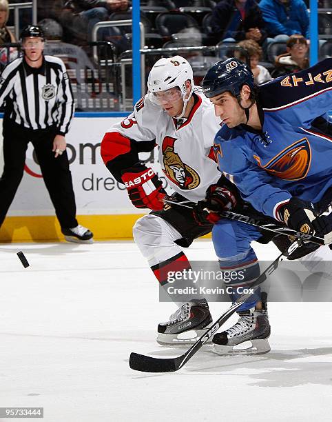 Chris Thorburn of the Atlanta Thrashers battles for the puck against Peter Regin of the Ottawa Senators at Philips Arena on January 12, 2010 in...