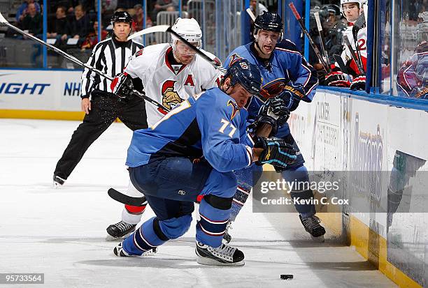 Pavel Kubina of the Atlanta Thrashers battles for the puck in front Mike Fisher of the Ottawa Senators and Rich Peverley at Philips Arena on January...