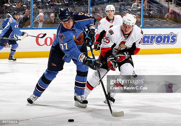 Pavel Kubina of the Atlanta Thrashers controls the puck against Chris Neil of the Ottawa Senators at Philips Arena on January 12, 2010 in Atlanta,...