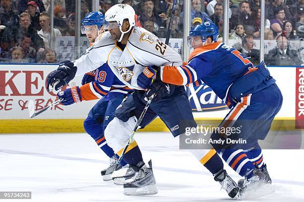 Ladislav Smid of the Edmonton Oilers tries to slow down Jerred Smithson of the Nashville Predators at Rexall Place on January 12, 2010 in Edmonton,...