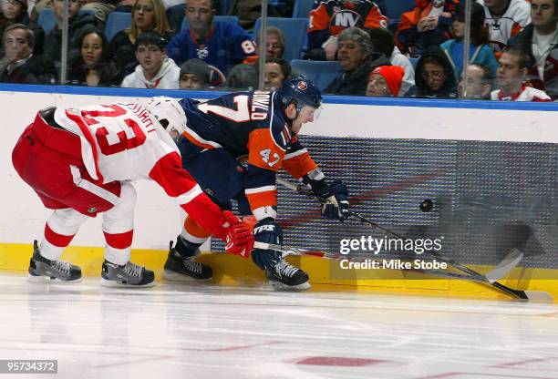 Andrew MacDonald of the New York Islanders and Brad Stuart of the Detroit Red Wings battle for the puck along the boards on January 12, 2010 at...