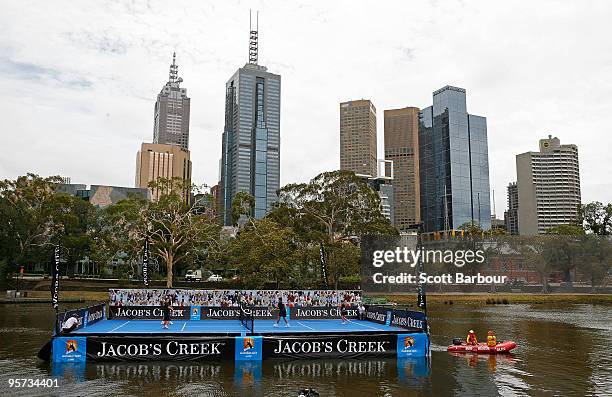 Former Australian tennis players Pat Rafter and Wally Masur play a game of tennis on a tennis court floating on the Yarra River during the the...