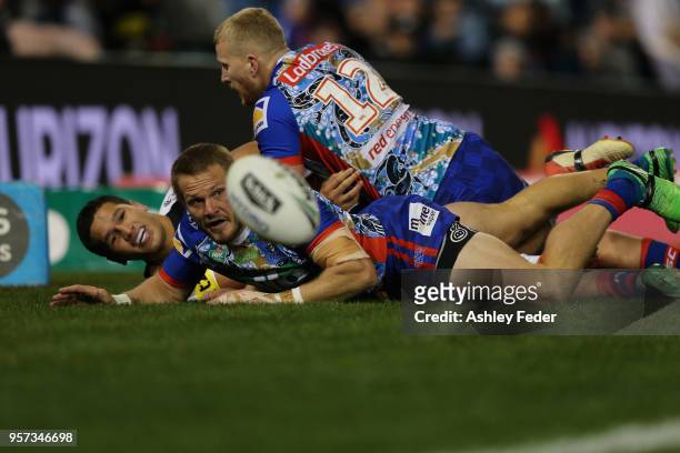 Nathan Ross of the Knights is tackled by Dallin Watene-Zelezniak of the Panthers during the round 10 NRL match between the Newcastle Knights and the...
