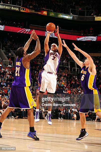 Jared Dudley of the Phoenix Suns takes a jump shot against Josh Powell and Adam Morrison of the Los Angeles Lakers during the game on December 28,...