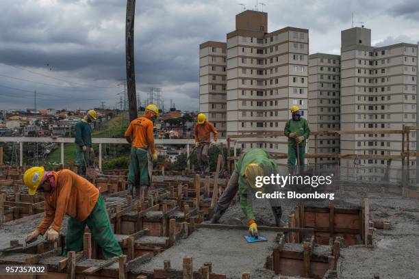 Contractors lay down cement during construction at the Reserva Paulista residential complex in Sao Paulo, Brazil, on Wednesday, March 21, 2018. The...