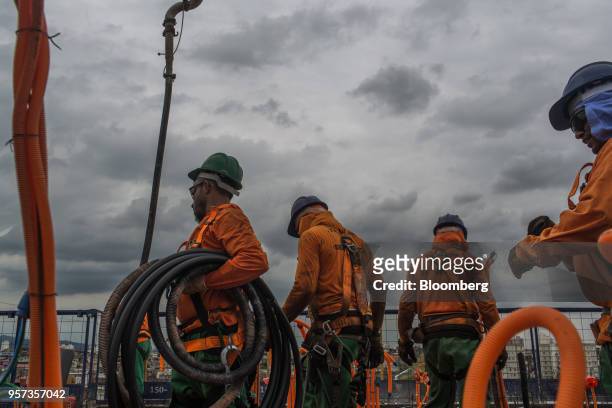 Contractor carries drainage tubing during construction at the Reserva Paulista residential complex in Sao Paulo, Brazil, on Wednesday, March 21,...