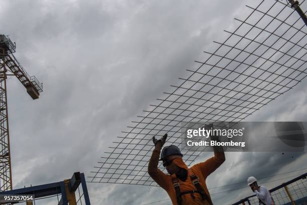 Contractors carries a mesh reinforcement panel during construction at the Reserva Paulista residential complex in Sao Paulo, Brazil, on Wednesday,...