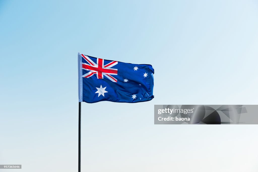Waving Australia flag against blue sky