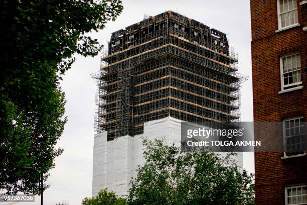 Construction work is seen continuing on the burned-out shell of Grenfell Tower in west London on May 11, 2018. - British Prime Minister Theresa May...