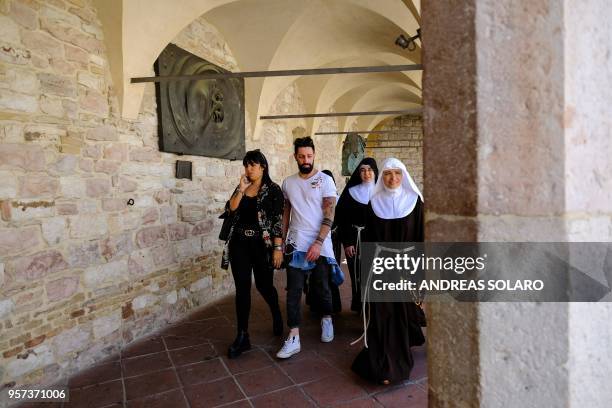 Tourists and nuns walk in the Loggia of the Basilica Superiore and the Basilica Inferiore of St Francis of Assisi, in Assisi, on May 11, 2018. -...