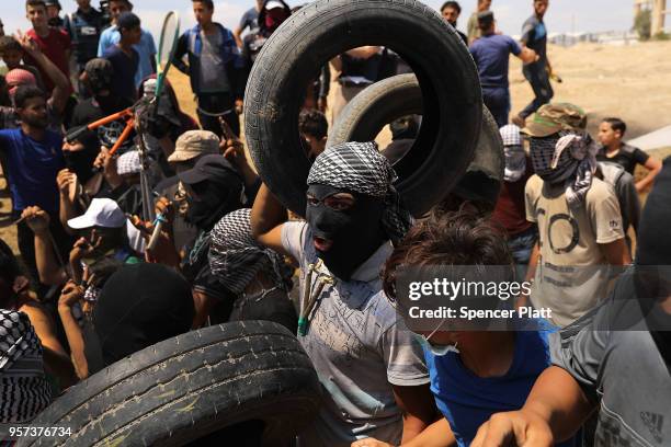 Palestinians prepare to burn tires near the border fence with Israel as mass demonstrations at the fence continue on May 11, 2018 in Gaza City, Gaza....