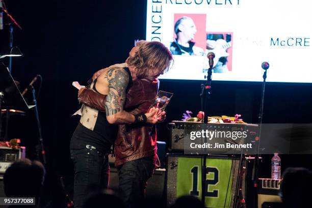 Bassist Duff McKagan presents Mike McCready with the Steve Ray Vaughan award live on stage during the MusiCares Concert for Recovery benefit at The...