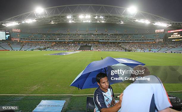 Usman Khawaja of the Blues signs bats during rain break at the Twenty20 Big Bash match between the New South Wales Blues and the Queensland Bulls at...