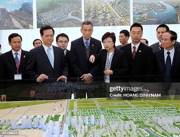 Visiting Singaporean Prime Minister Lee Hsien Loong and his Vietnamese counterpart Nguyen Tan Dung look at a scale model of the VSIP Hai Phong...