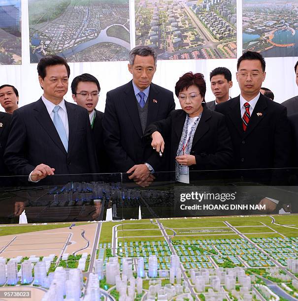 Visiting Singaporean Prime Minister Lee Hsien Loong and his Vietnamese counterpart Nguyen Tan Dung look at a scale model of the VSIP Hai Phong...