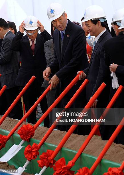 Visiting Singaporean Prime Minister Lee Hsien Loong and his Vietnamese counterpart Nguyen Tan Dung shovel sand as they attend the ground-breaking...