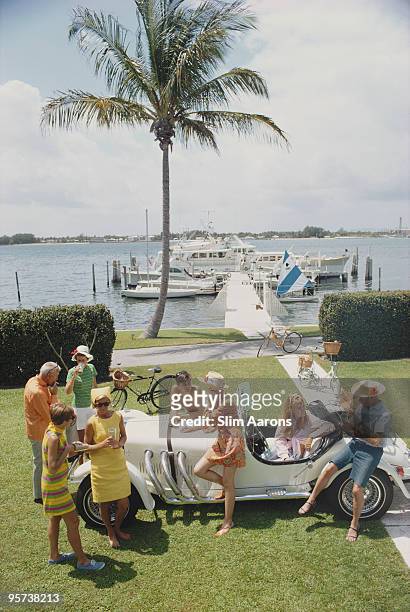 Palm Beach socialite Jim Kimberly and friends around his white sports car on the shores of Lake Worth, Florida, April 1968.