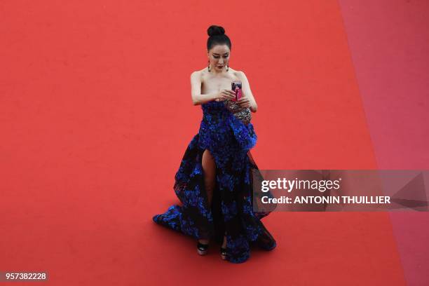 Guest takes a selfie photo as she arrives on May 8, 2018 for the screening of the film "Todos Lo Saben " and the opening ceremony of the 71st edition...