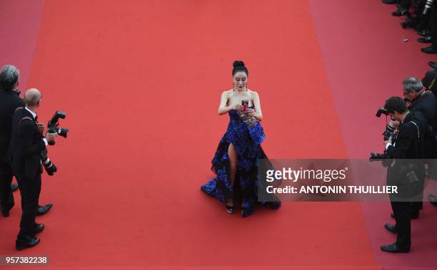 Guest takes a selfie photo as she arrives on May 8, 2018 for the screening of the film "Todos Lo Saben " and the opening ceremony of the 71st edition...