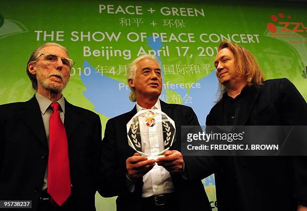 Led Zeppelin guitarist Jimmy Page holds an award presented by Michael Johnson , the United Nations NGO representative for Pathways to Peace as...