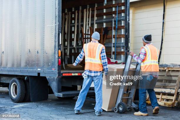 dos trabajadores con un camión, caja grande en movimiento - camión de las mudanzas fotografías e imágenes de stock