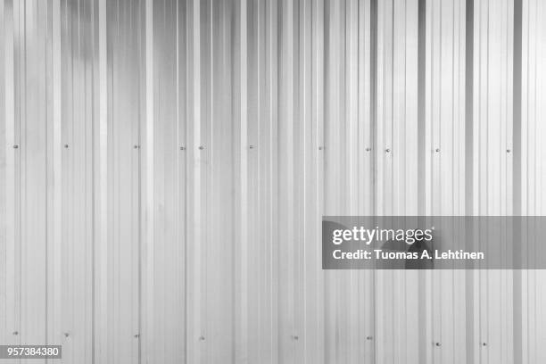 full frame background of shiny corrugated galvanized metal wall texture in black and white - sheet metal fencing stock pictures, royalty-free photos & images
