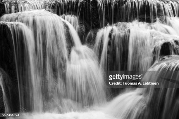 full frame close-up of a cascade at the tat kuang si waterfalls near luang prabang in laos. natural abstract art in black and white. - kuang si falls stock pictures, royalty-free photos & images