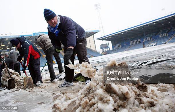 Portsmouth fans clear snow from Fratton Park stadium before the weekend match against Birmingham City on December 13, 2009 in Portsmouth, England....