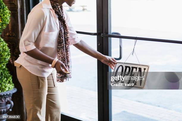 african-american woman opening store, turning sign - open day 9 stock pictures, royalty-free photos & images