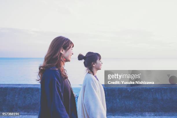 two young women laughing while talking - beach girl ストックフォトと画像