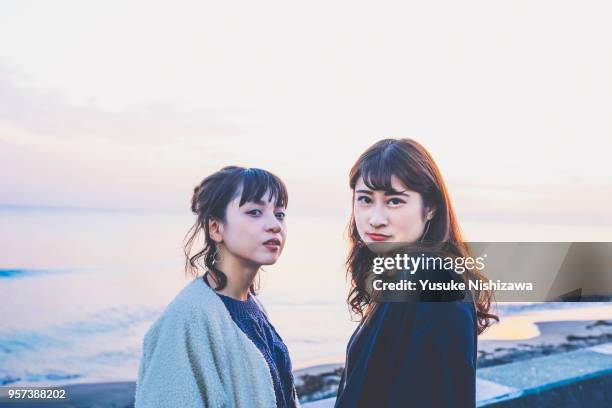 two young women looking at one point - teenager staring imagens e fotografias de stock