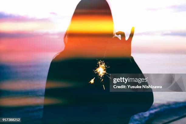 silhouette of a woman wearing fireworks - dedo mindinho imagens e fotografias de stock