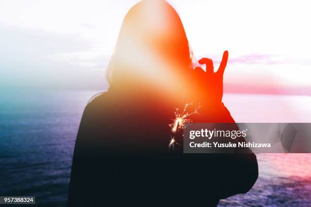 silhouette of a woman wearing fireworks - girl beach sunset bildbanksfoton och bilder