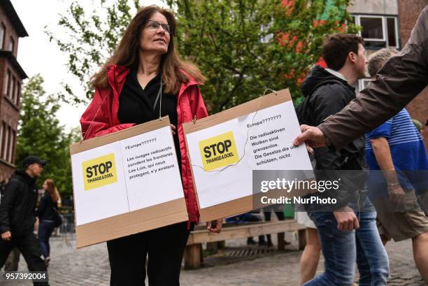 Woman holding protest banners against nuclear plants Tihange and Doel outside the city hall where the Charlemagne prize award ceremony takes place on...