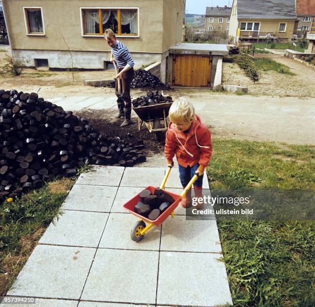 Ein kleiner Junge mit einer Kinderschubkarre hilft beim sogenannten Kohleeinkellern in einer Straße der Gemeinde Frießnitz bei Gera, undatiertes Foto...