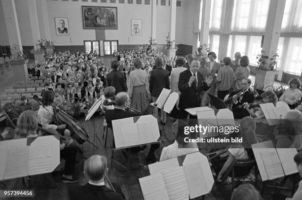 Offizieller Festakt einer Jugendweihe in der Bergbauschule in der Lutherstadt Eisleben, aufgenommen im März 1982. Im Hintergrund hängen Porträtbilder...