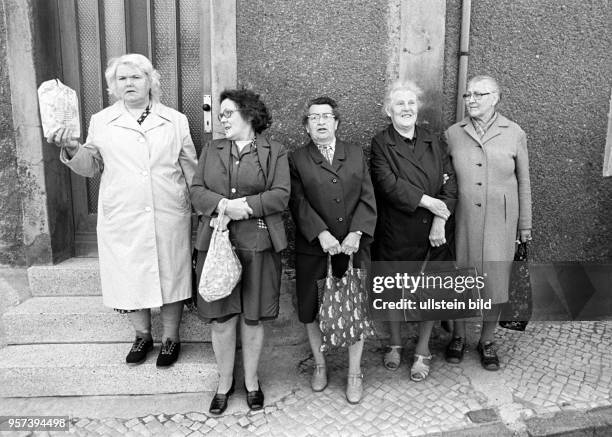Alte Frauen stehen am Straßenrand betrachten das Treiben einer Hochzeitsgesellschaft, aufgenommen am in Mansfeld im Kupferbergbau-Gebiet Mansfelder...