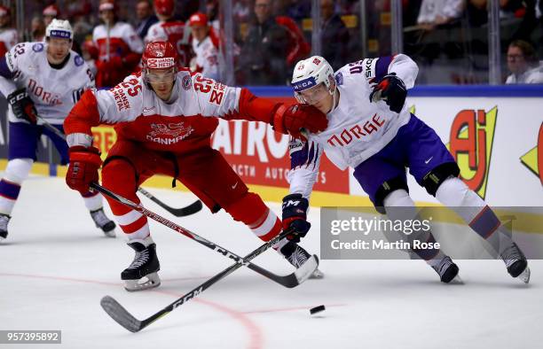 Oliver Lauridsen of Denmark and Christian Bull of Norway battle for the puck during the 2018 IIHF Ice Hockey World Championship Group B game between...