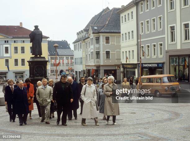 Touristen auf dem Marktplatz der Lutherstadt Eisleben, im Hintergrund das Lutherdenkmal, undatiertes Foto von 1983. 1983 wurde anlässlich des 500....