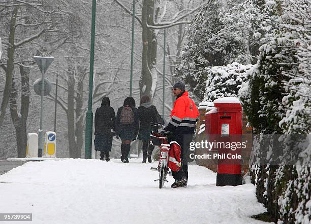 Postman collects post in the snow on January 13, 2010 in Carshalton, England. Further snow showers have caused the closure of Gatwick Airport and a...