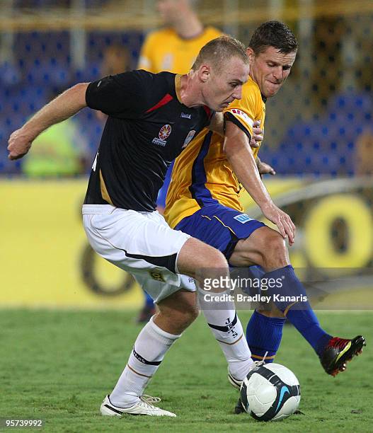 Jabe Wheelhouse of the Jets is challenged by the defence of Jason Culina of the Gold Coast during the round 19 A-League match between Gold Coast...