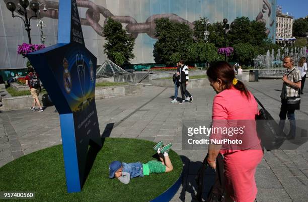 Man looking alike Russian president Vladimir Putin looks from a side at a woman taking picture of her kid near a big star announcing UEFA Women's...