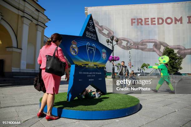 People take pictures near a big star announcing UEFA Women's Champions League and UEFA Champions League finas at Independence square downtown Kyiv,...