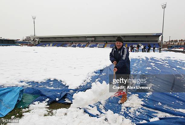 Volunteers help clear snow from the pitch at Macclesfield Town Football Club on January 13, 2010 in Macclesfield, United Kingdom. Macclesfield Town...