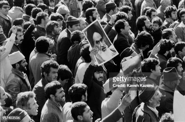 Posters of Ayatollah Khomeini who leads the Iranian Revolution from Paris, France is carried by demonstrators marching in Shah Reza avenue in Tehran,...