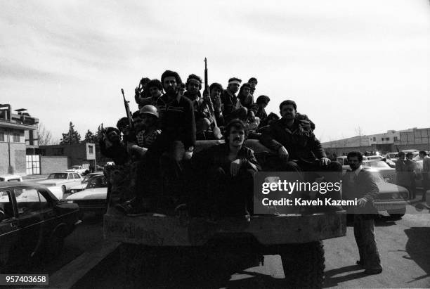 Victorious group of men carrying arms drive around the city after having looted army garrisons in the late afternoon on the victory day of the...