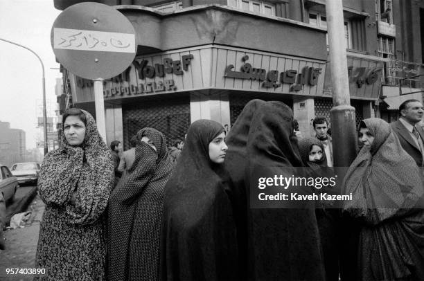 Chador clad women stand in front of a "Shah Ran" slogan sprayed on a no entry street sign in Shah Reza avenue a few days after the Shah fled the...